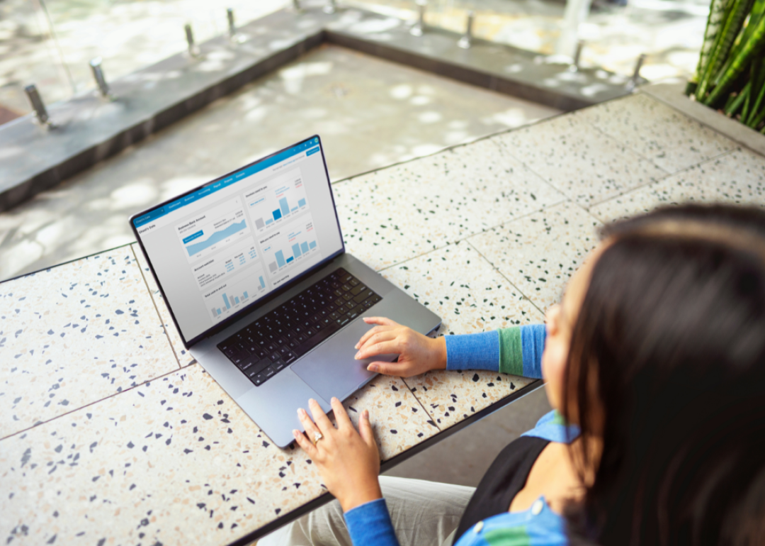 A person checking financial graphs and charts from a laptop.