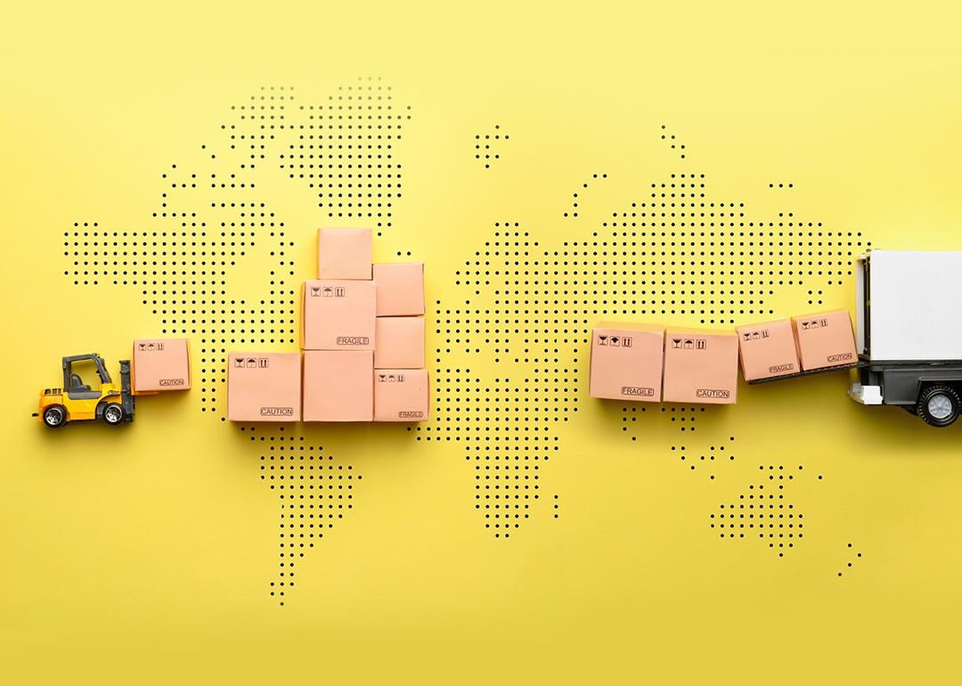 A loader loads goods into a truck against the backdrop of a world map.