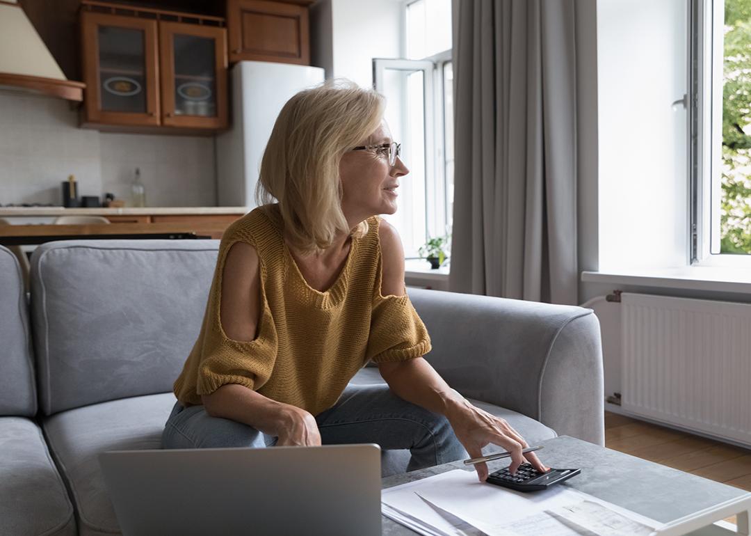 A female homeowner in deep thought while calculating home expenses.