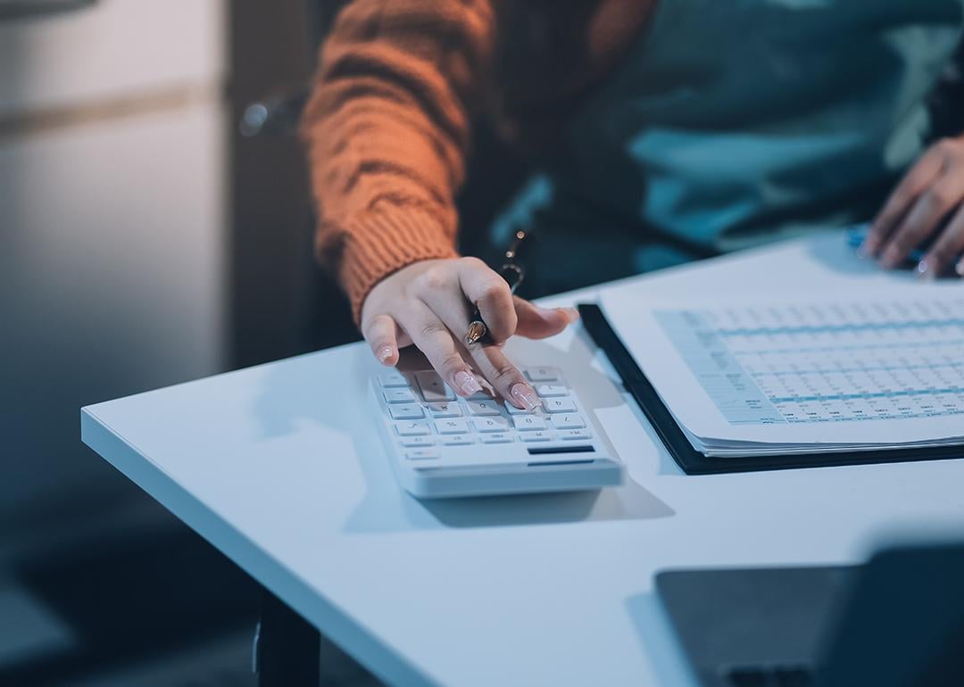 Worker calculating finance reports using a calculator.