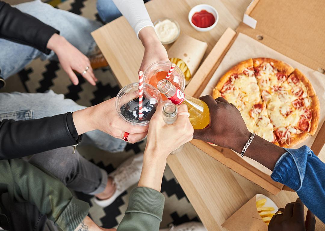 People raising their glass beverages while celebrating at home.