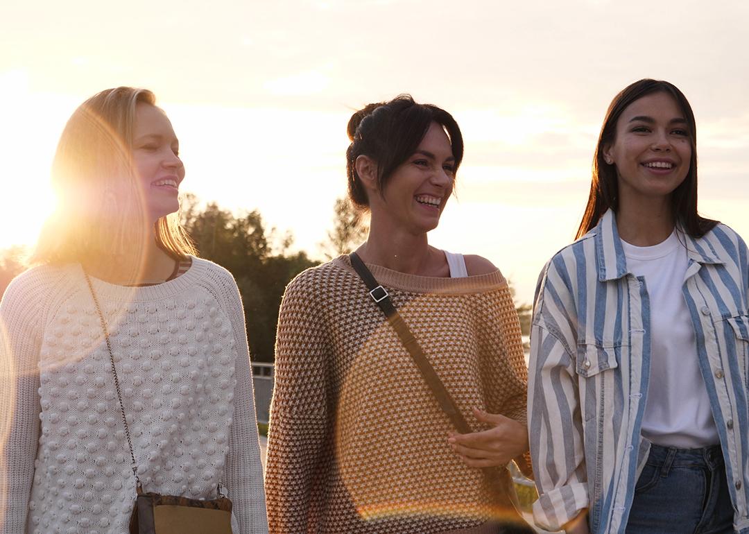 A group of friends enjoying a good time and walking down a waterfront.