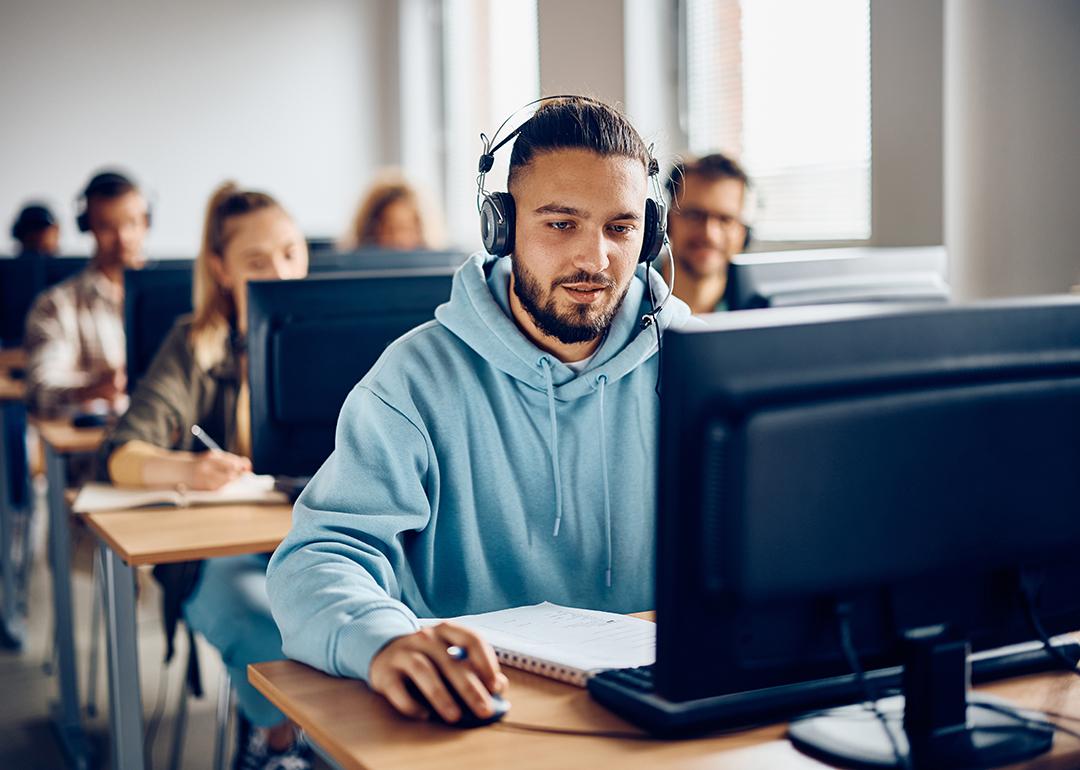 A male university student using a desktop computer during a class.