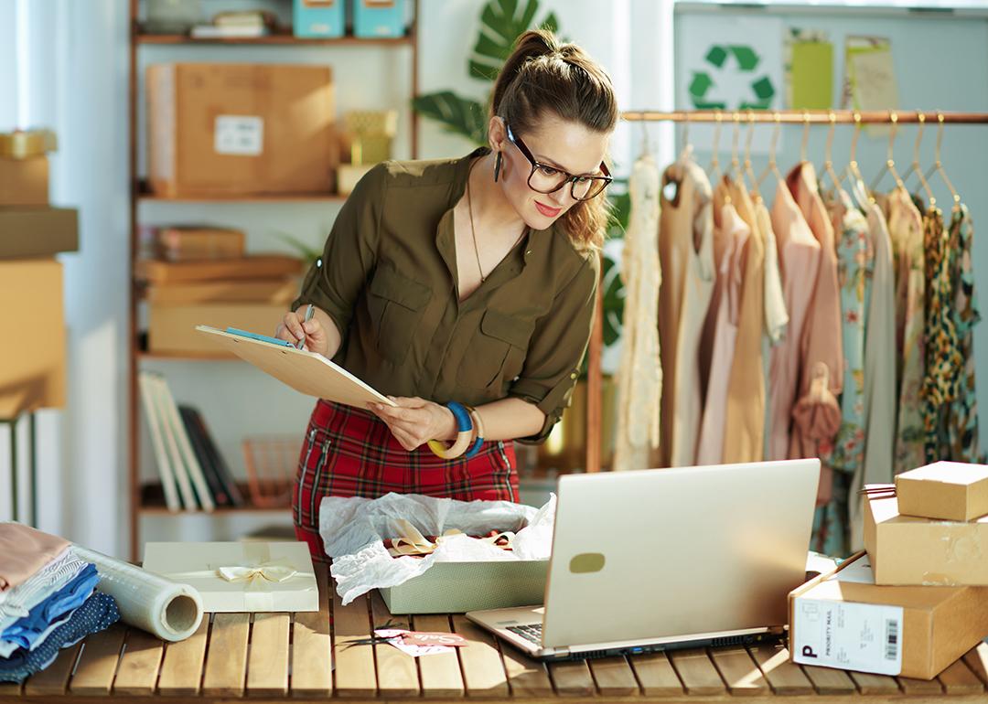A female small business owner checking a customer's order from a laptop.
