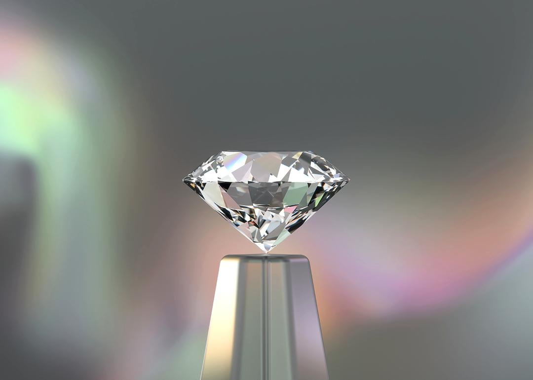 A 3D rendering of a round diamond with an iridescent backdrop.