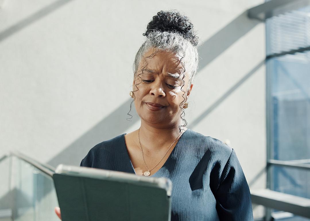 A female HR professional looking confused while reading information from a tablet.