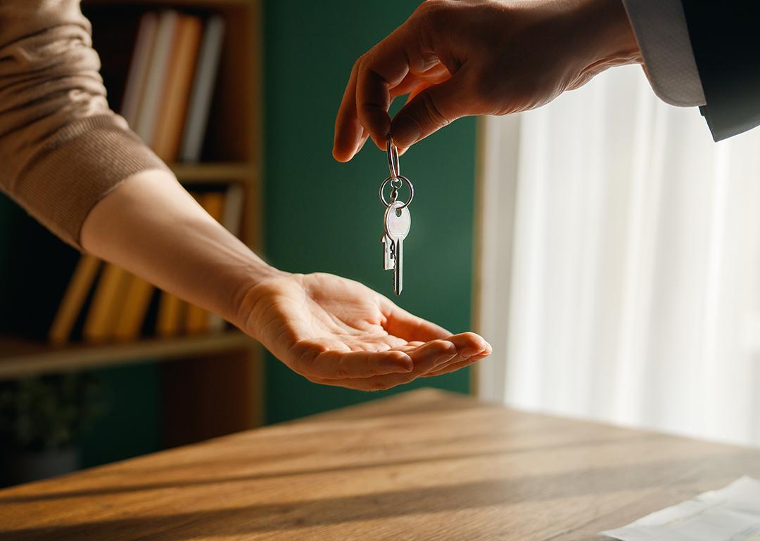 A new homeowner receives keys from real estate agent.