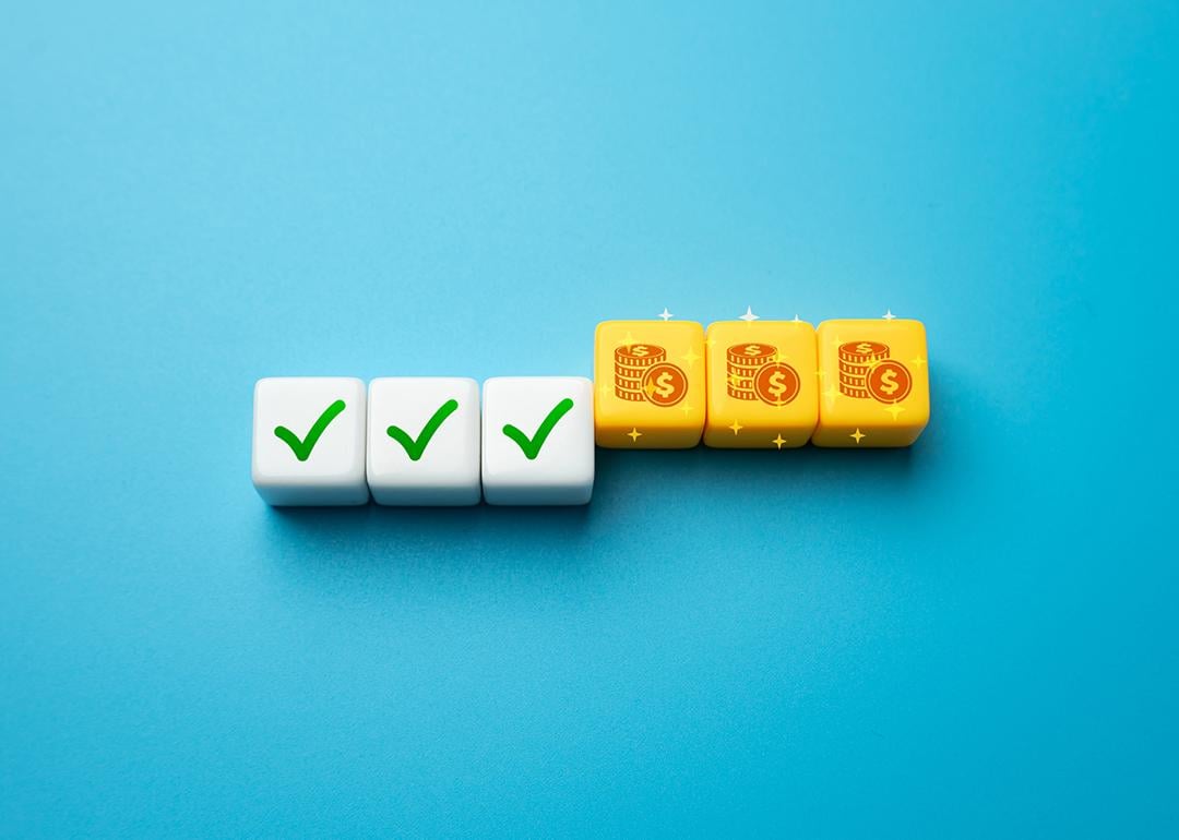 A die set with half showing a green check symbol and the other half are coin icons as a concept of incentive strategy.