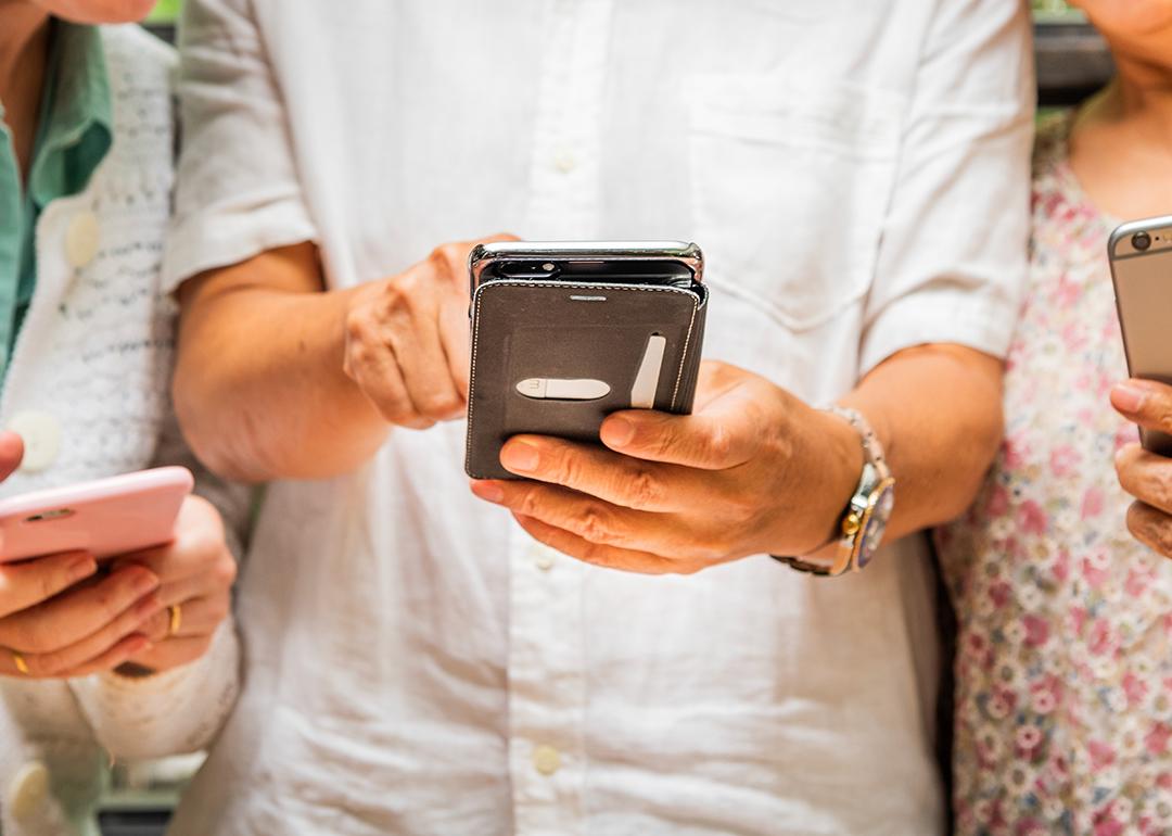 People using and sharing their smartphones' content with each other.