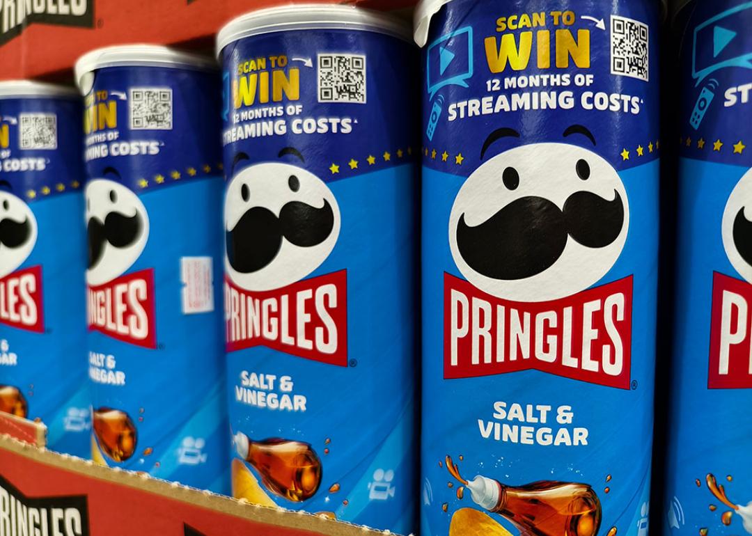 Cans of Pringles on a shelf featuring a QR code for a contest.
