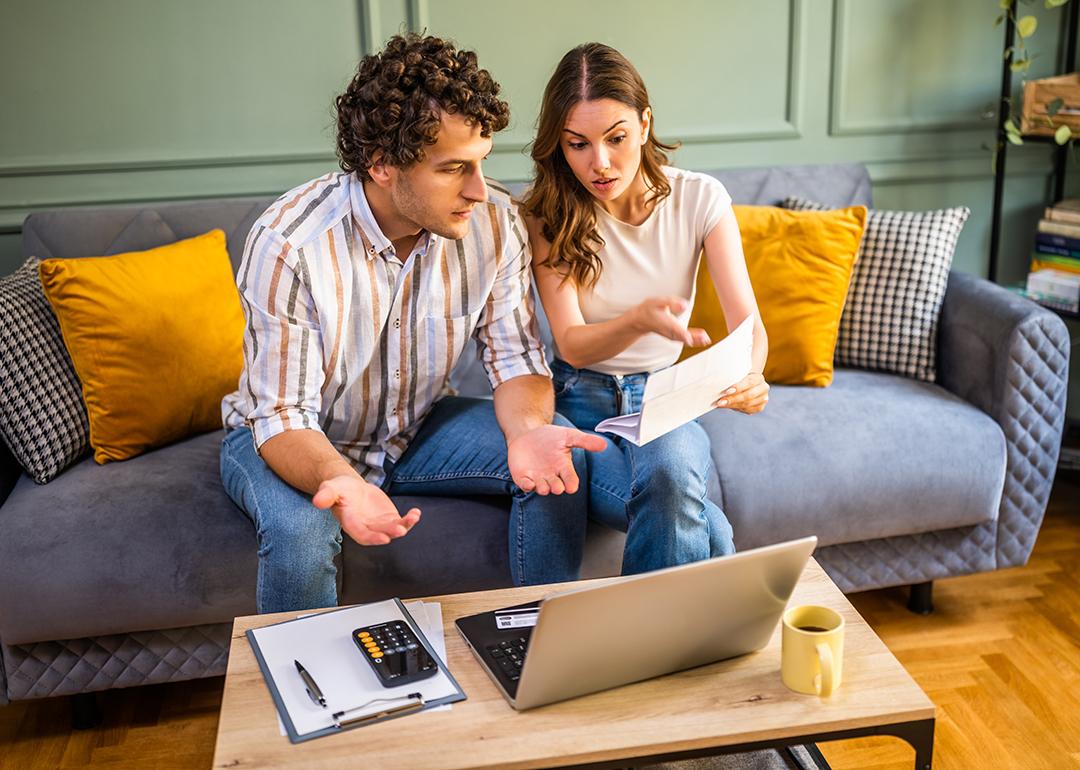 A young couple at home discussing bills.