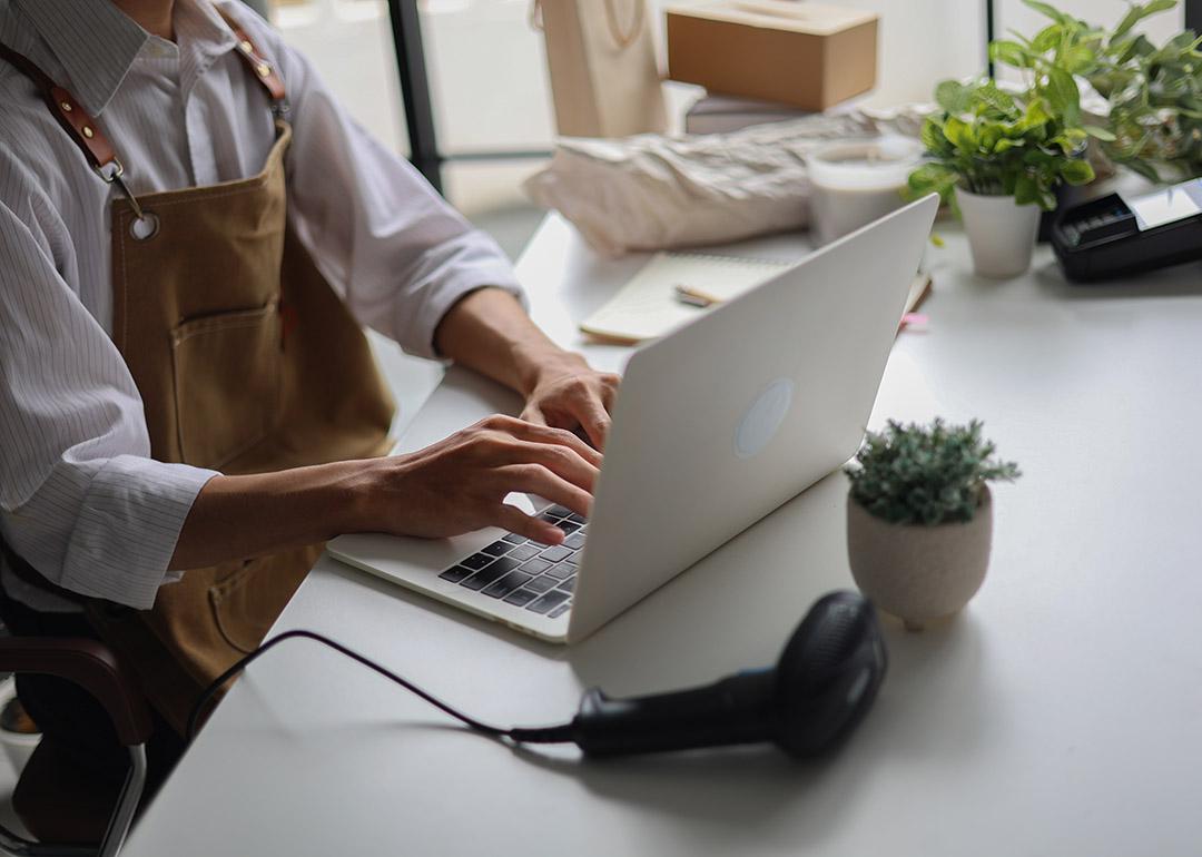 A cafe owner managing online orders from a laptop.