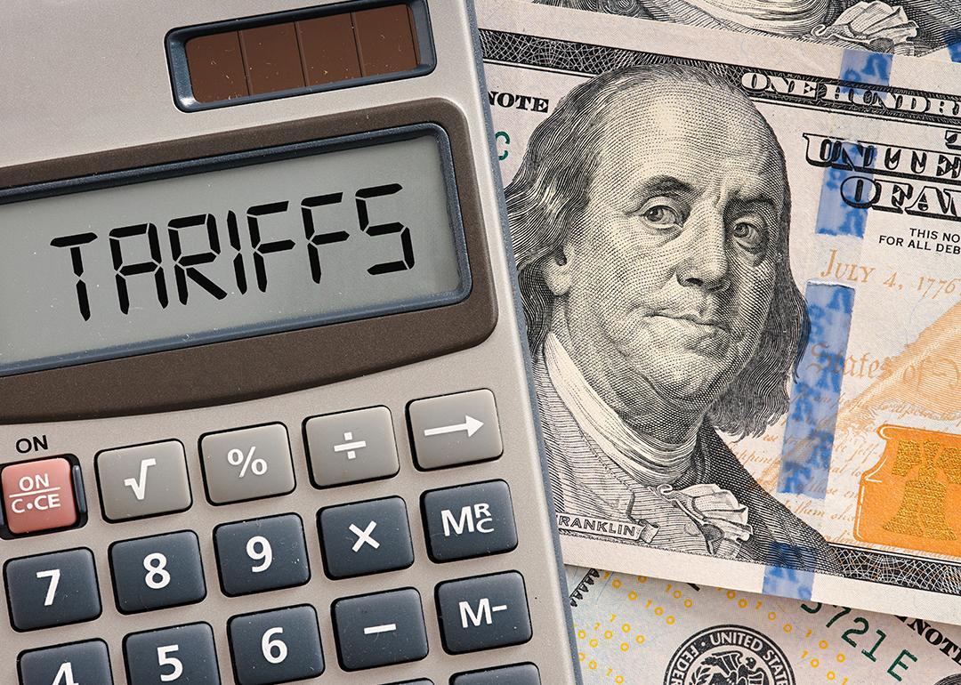 A calculator displaying the word 'tariffs' on top of a US dollar banknote.