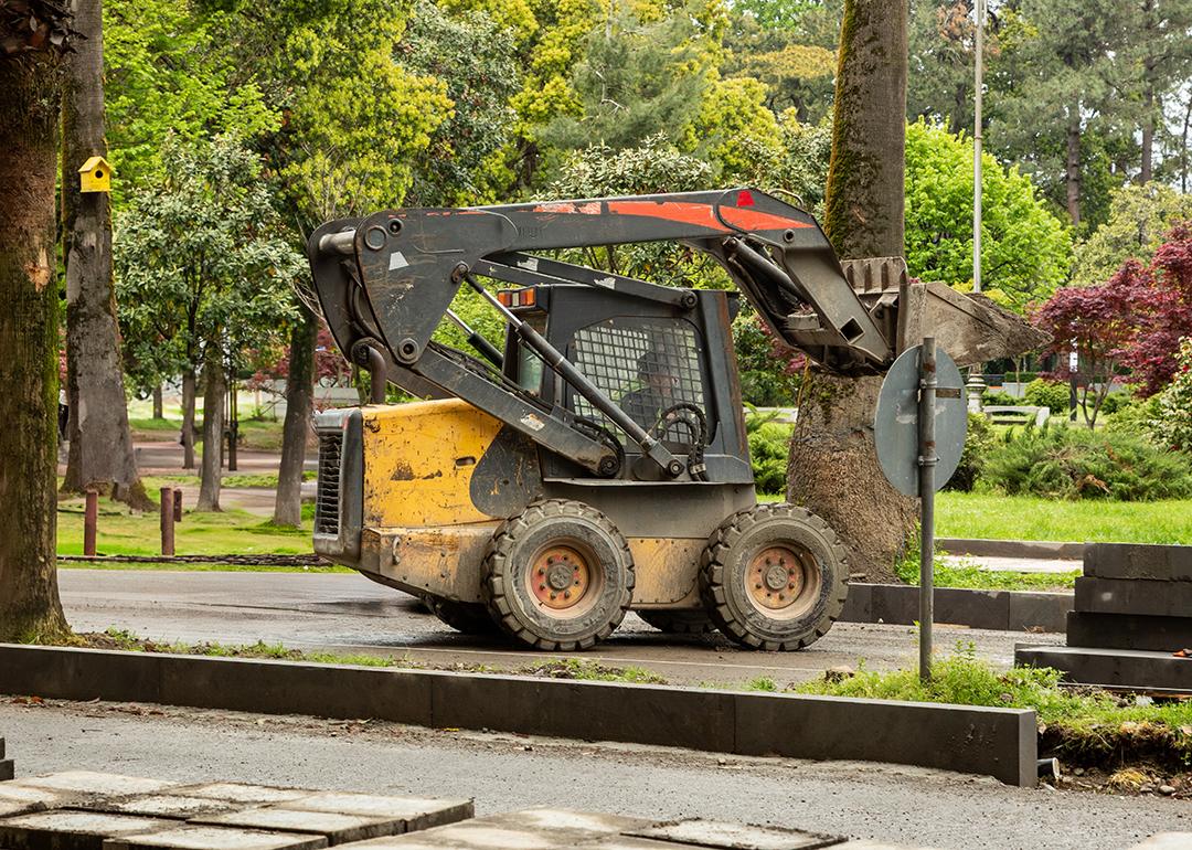 A skid steer loader operating on the park.