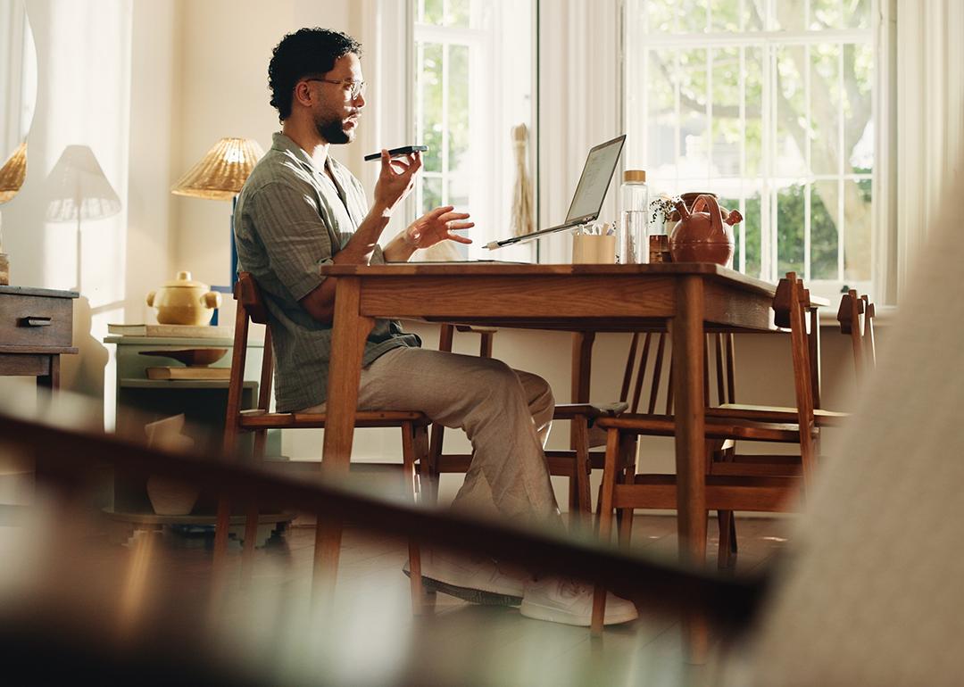 A businessman working from home and talking on the phone.