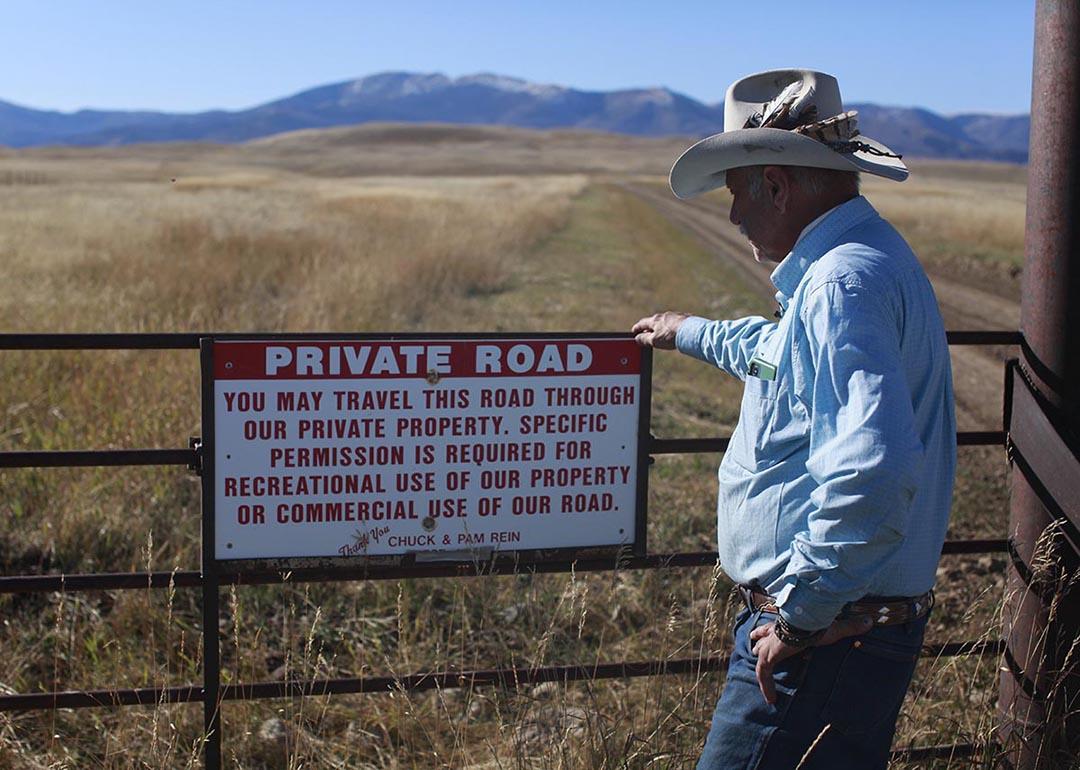 Brad Wilson stands beside a dirt road that leads to a century-old public trail that was abandoned by the U.S. Forest Service as part of a controversial land swap.