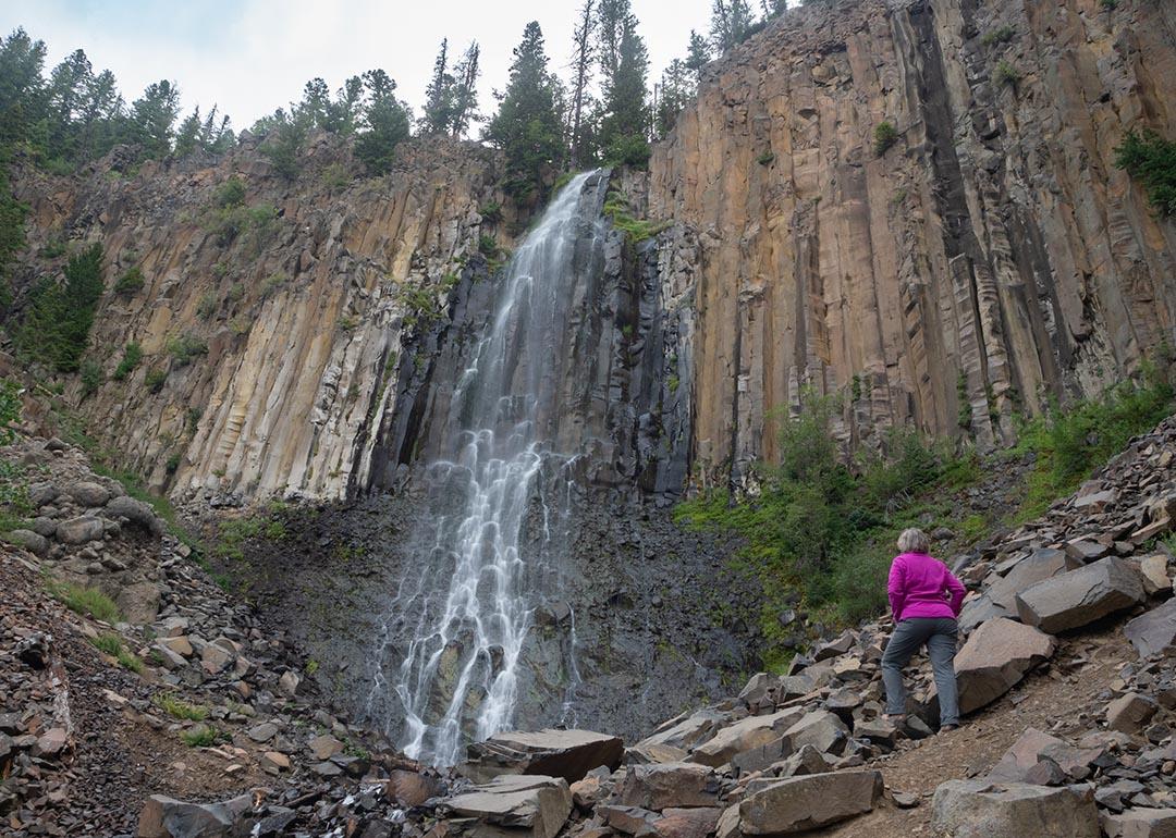 A senior woman at the base of Palisade Falls in Montana.