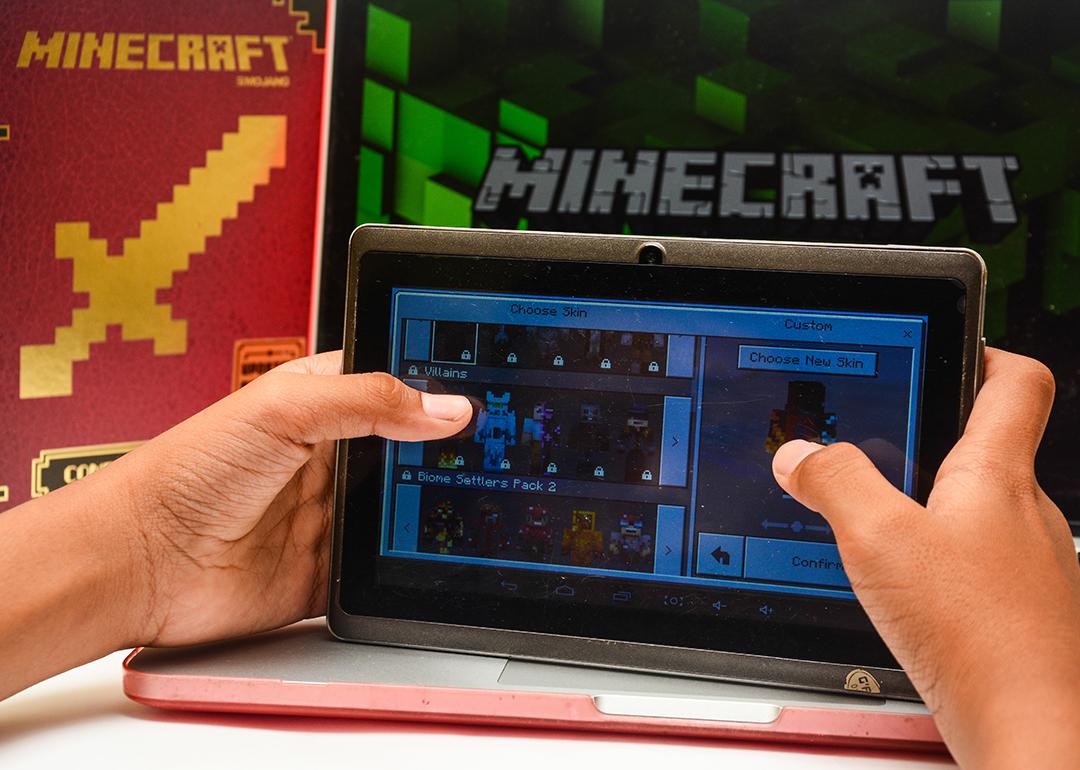 A young child paying Minecraft on a digital tablet.