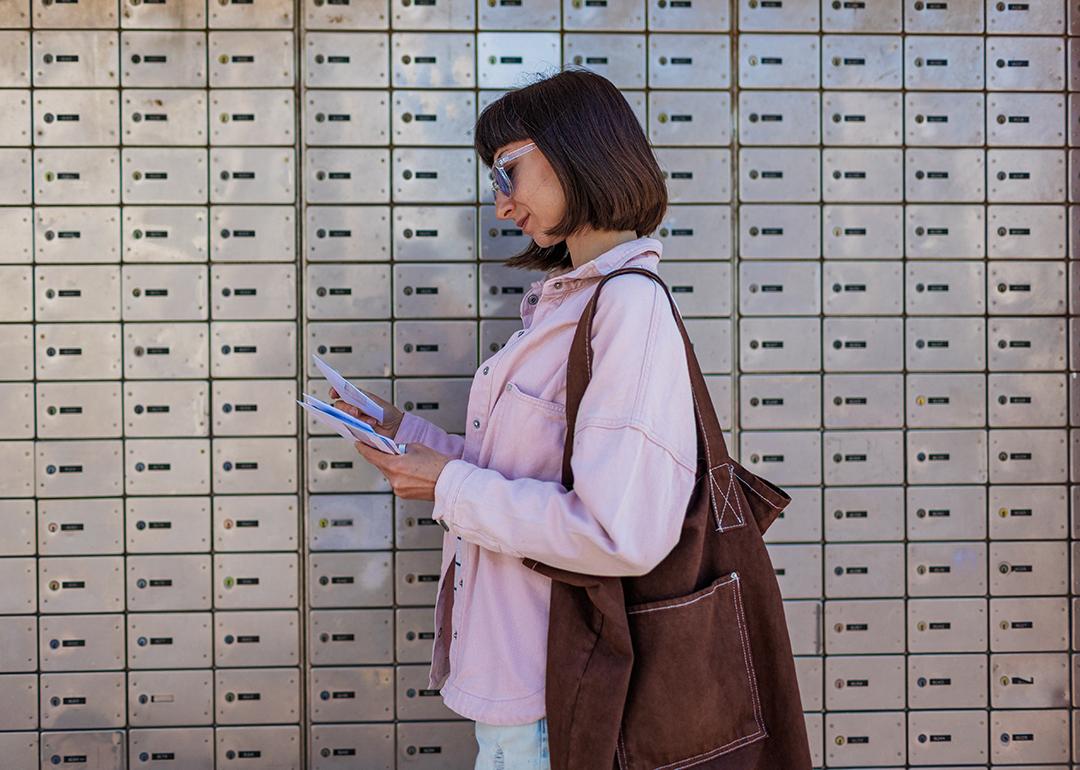 A woman sorting through her letters from the mailbox.