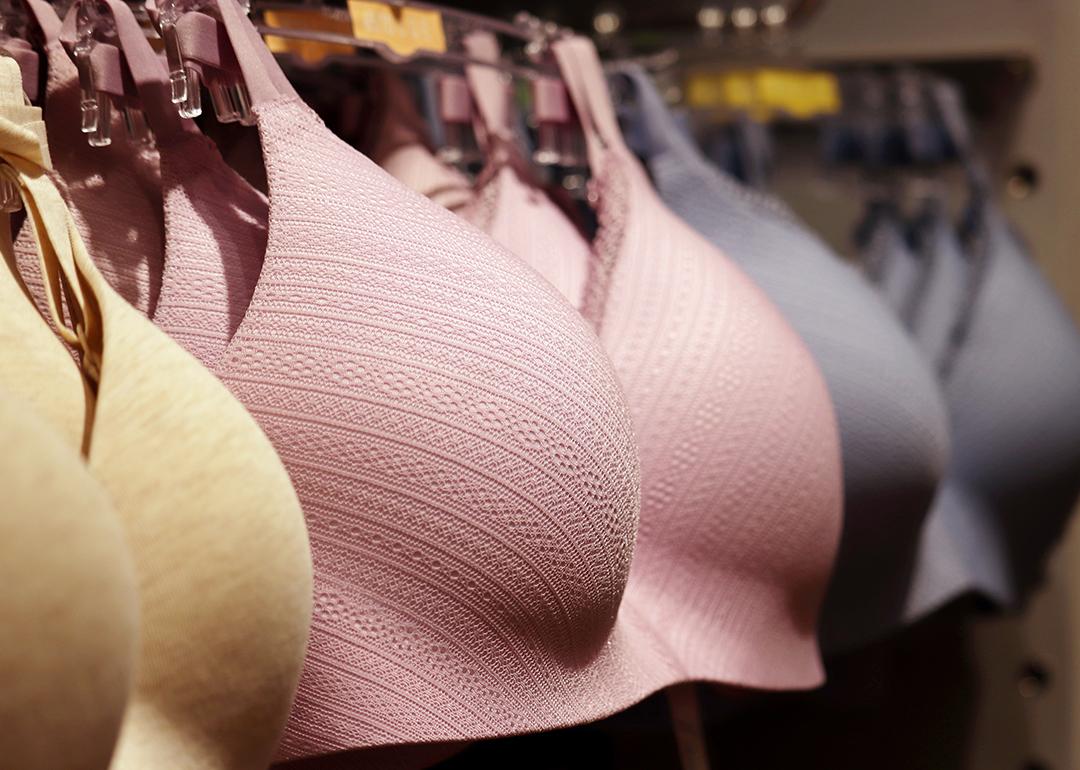Different sizes and colors of wireless bras on a lingerie store rack.