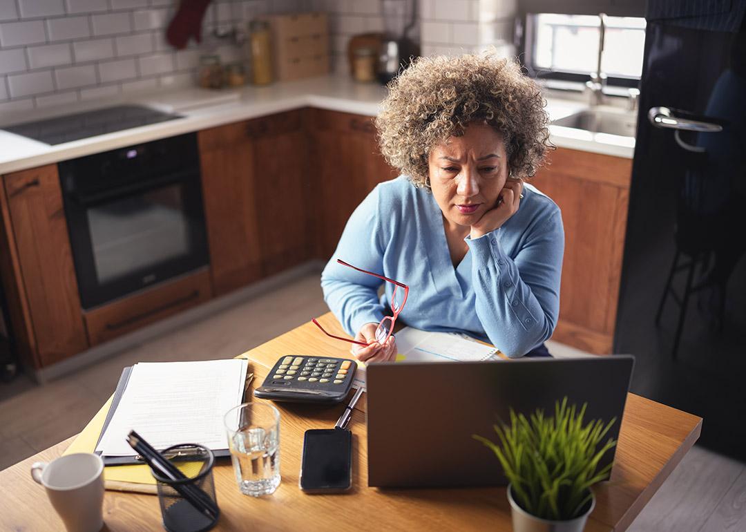 An entrepreneur reviewing budget, expenses, and payments of her business from a laptop.
