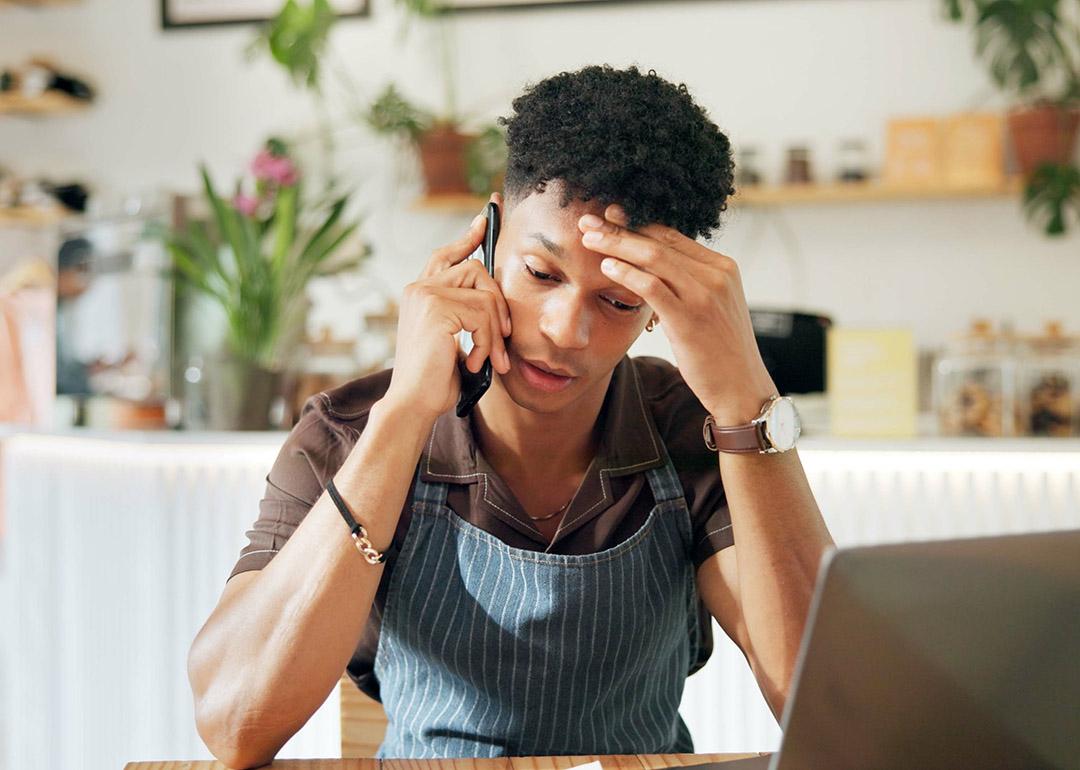 A business owner appearing to be frustrated while on a call because of loan application woes.