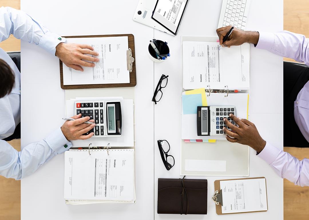 An overhead shot of a tax accountant and an auditor checking on receipts in an office.