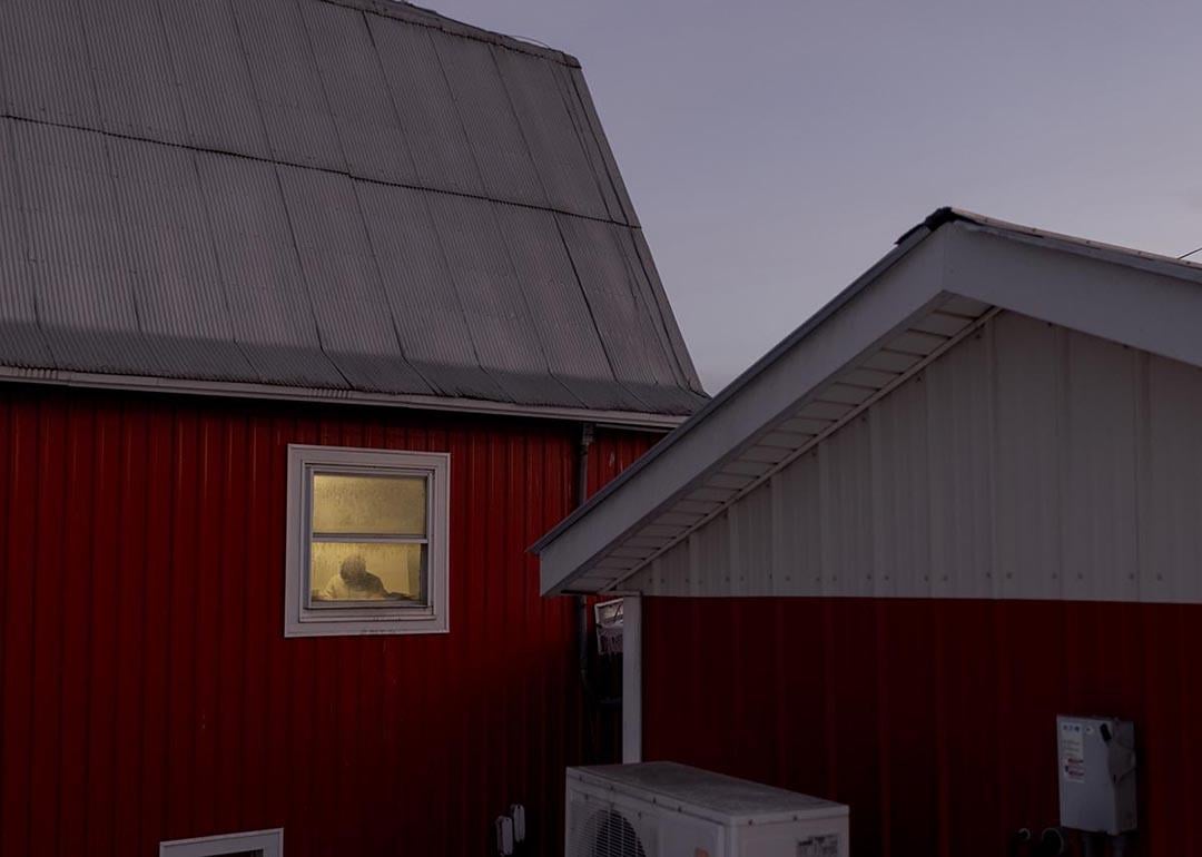 A worker can be seen by the window of one of the dairy farm properties at Pleasant Valley Farms in Vermont.