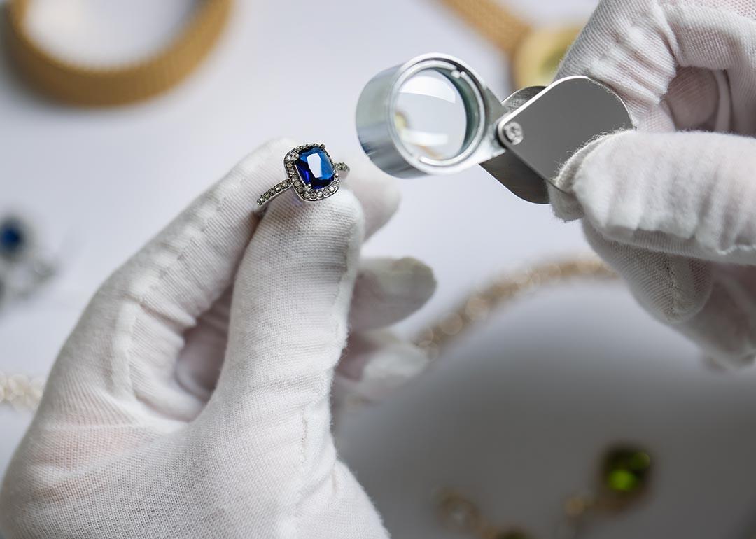 An appraiser inspecting a blue diamond ring.