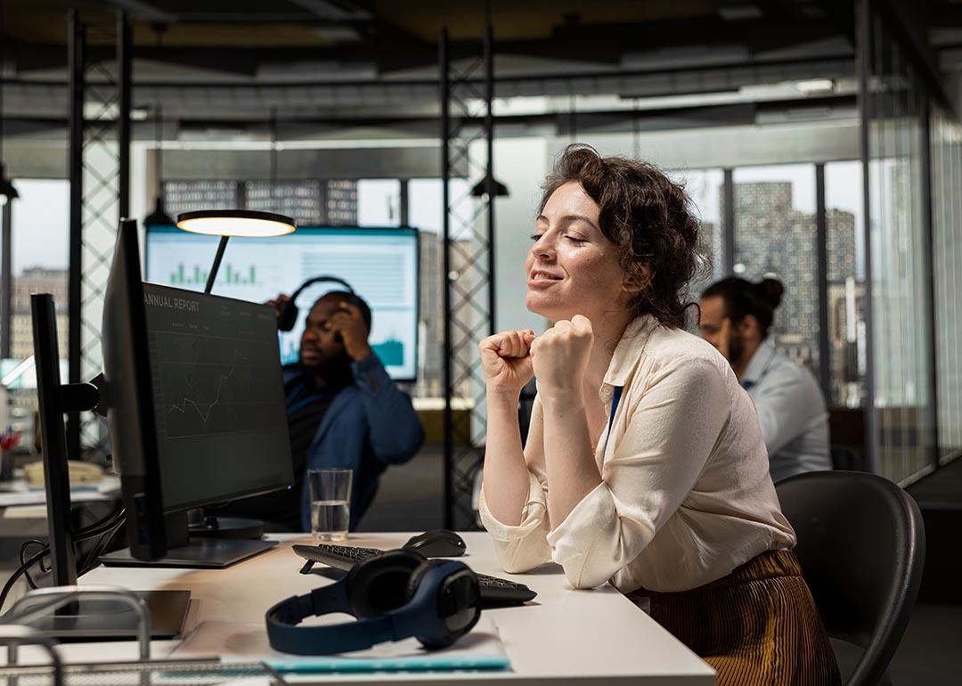 An employee appearing to be pleased after stock exchange's charts go upward.