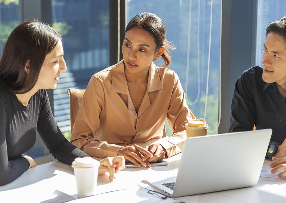 A small group of employees discussing work-related matters during a meeting.