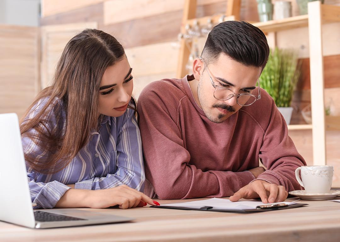 A young couple reviewing an insurance contract in a cafe.