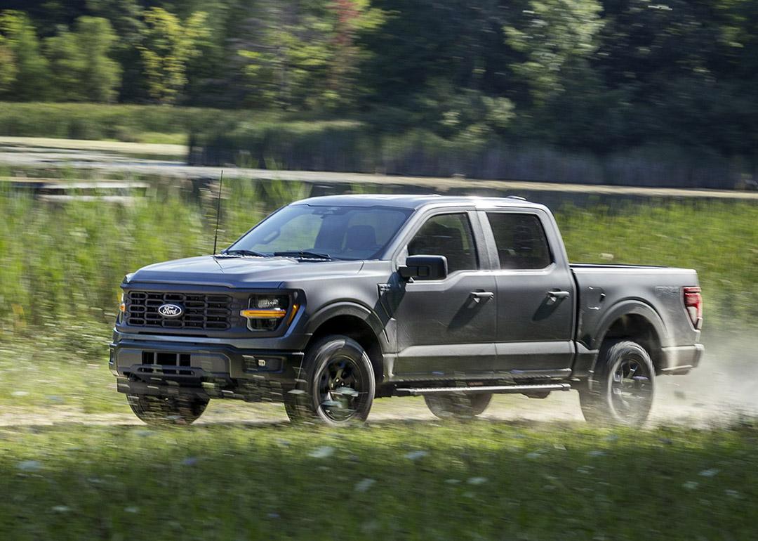A black Ford F-150 pickup truck on the road.