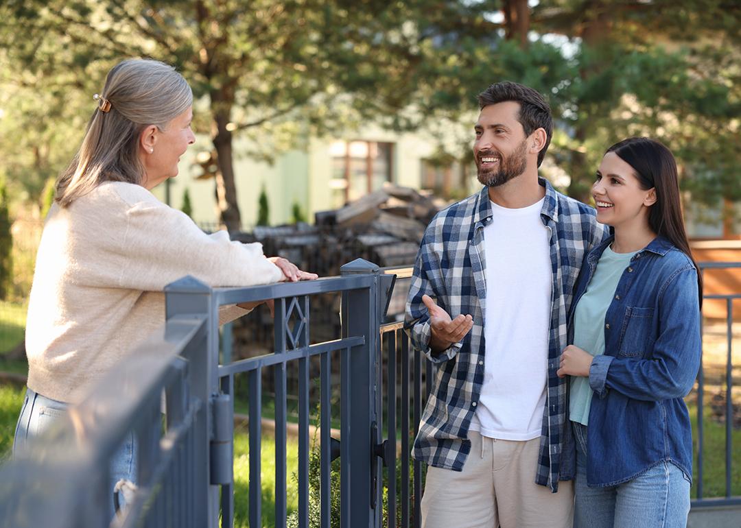 A young couple talking to a friendly elderly neighbor.