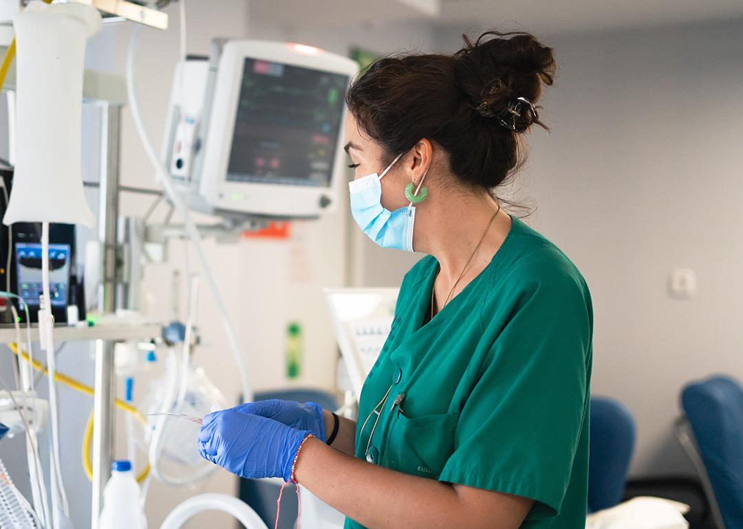 An ICU nurse working with medical monitors.