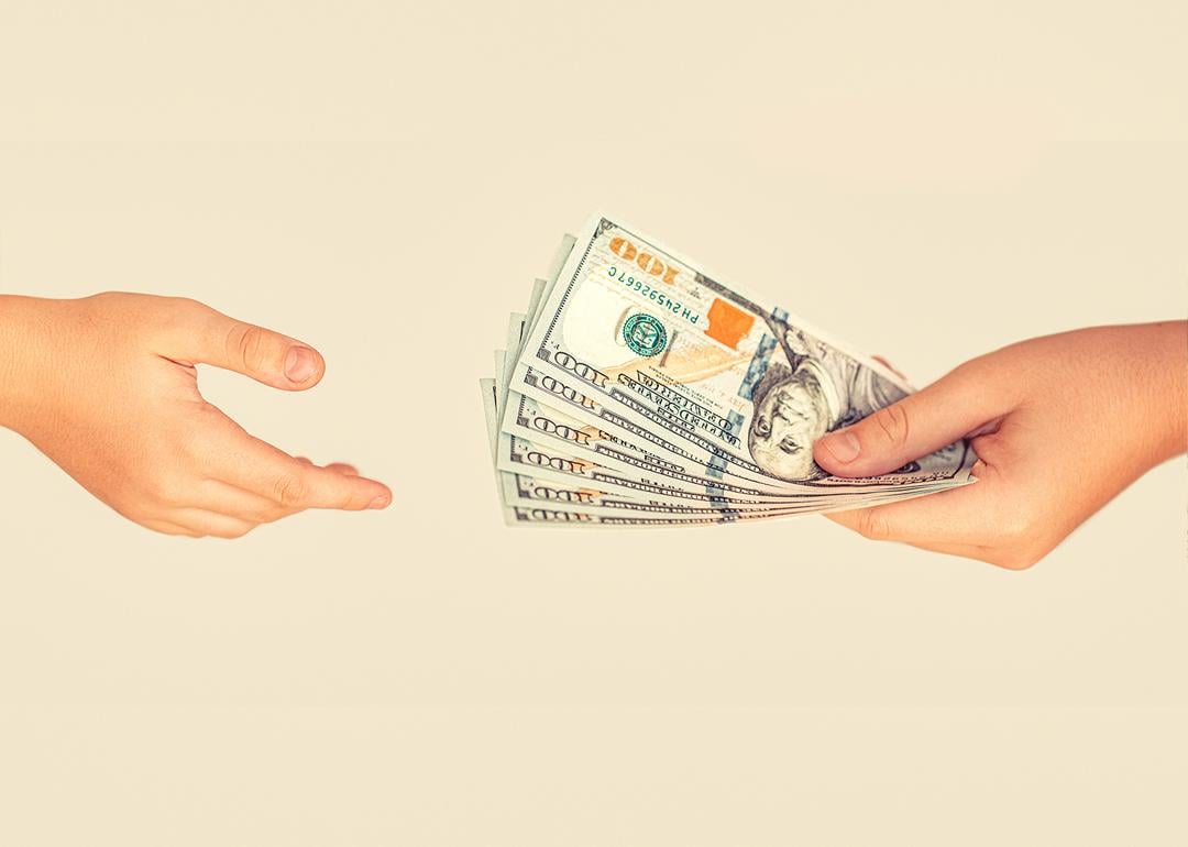 A financial transaction where one person is handing US banknotes to another person.