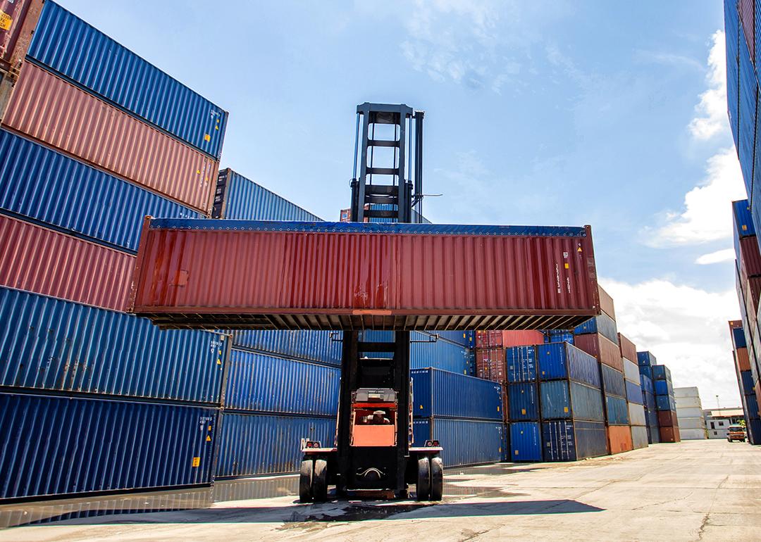 A cargo container being lifted in a shipping yard.