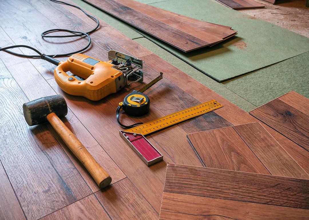 A rubber hammer, an electrofret, and a joiner angle gathered on a laminated floor.