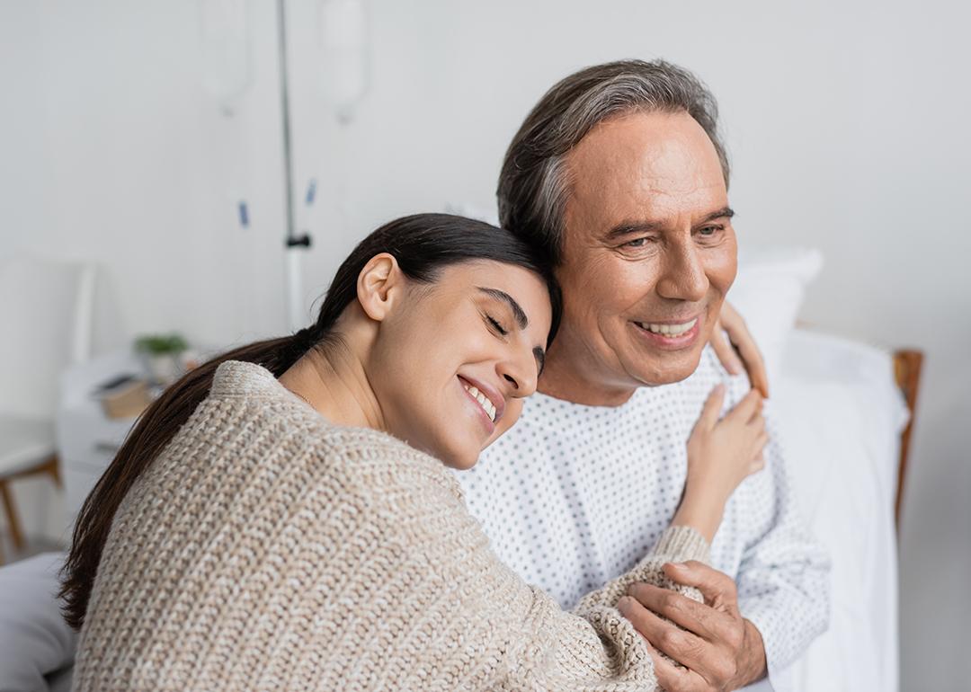A daughter hugging her father, who is recovering from an illness in the hospital.