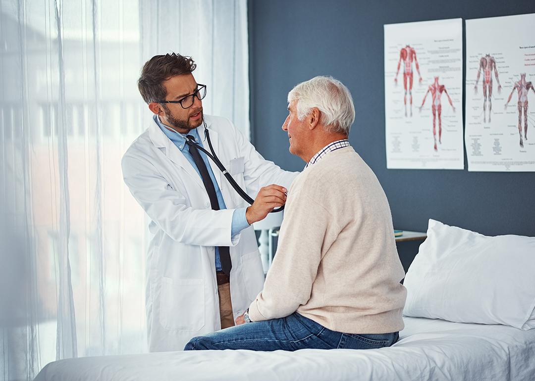 A doctor assessing an elderly person's breathing with a stethoscope during a medical check-up.