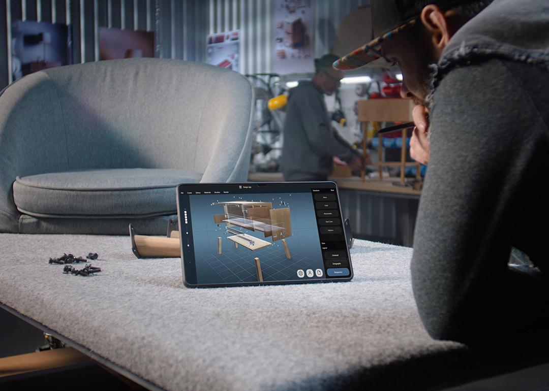 A designer creating a 3D model of a wooden bedside table through a AI software for furniture design.