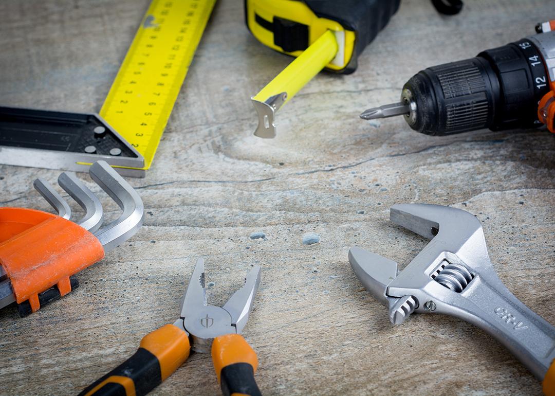 Assorted construction hand tools scattered on a work surface.