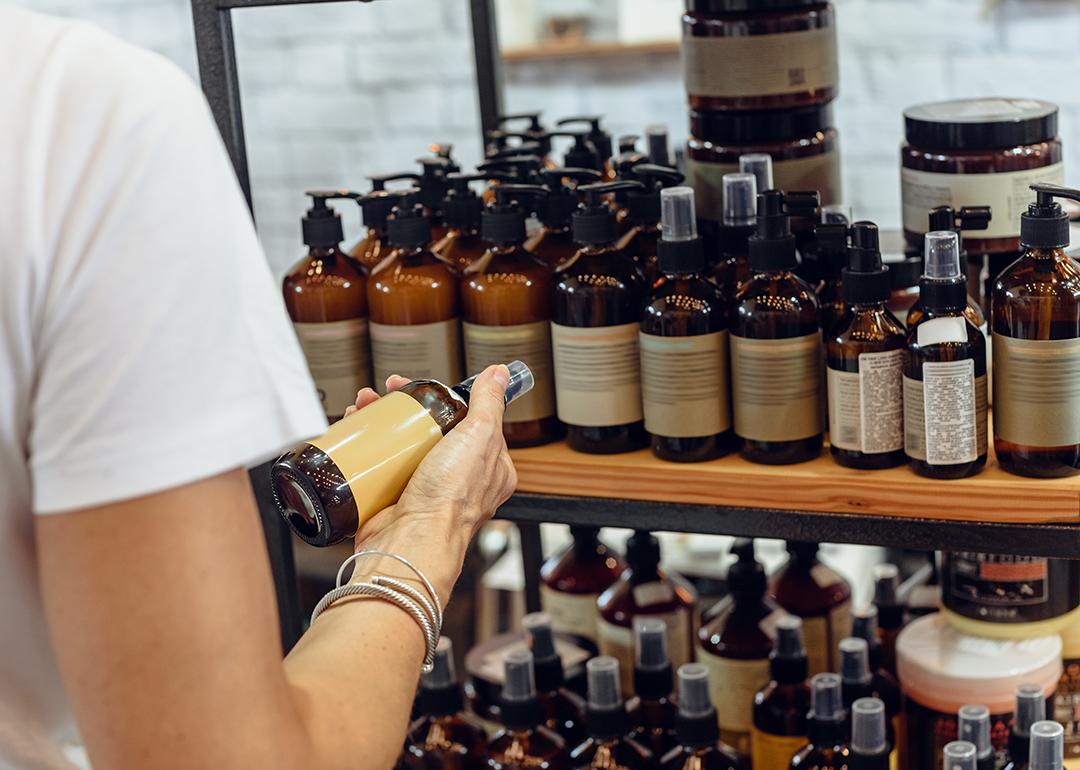 A customer choosing an item among organic cosmetic bottled products.