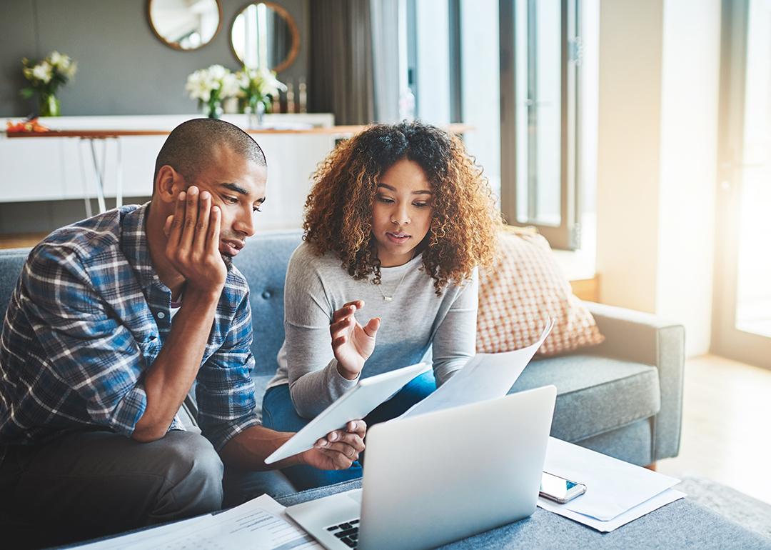 A young couple calculating expenses at home.