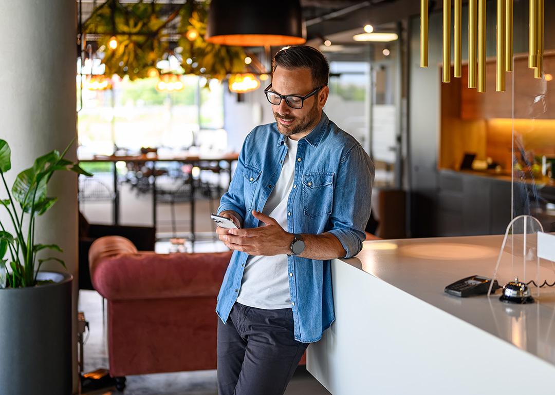 A businessman checking social media from his smartphone for their business' marketing.
