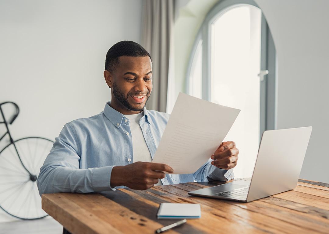 A young adult reading an important letter of his personal achievement at work.