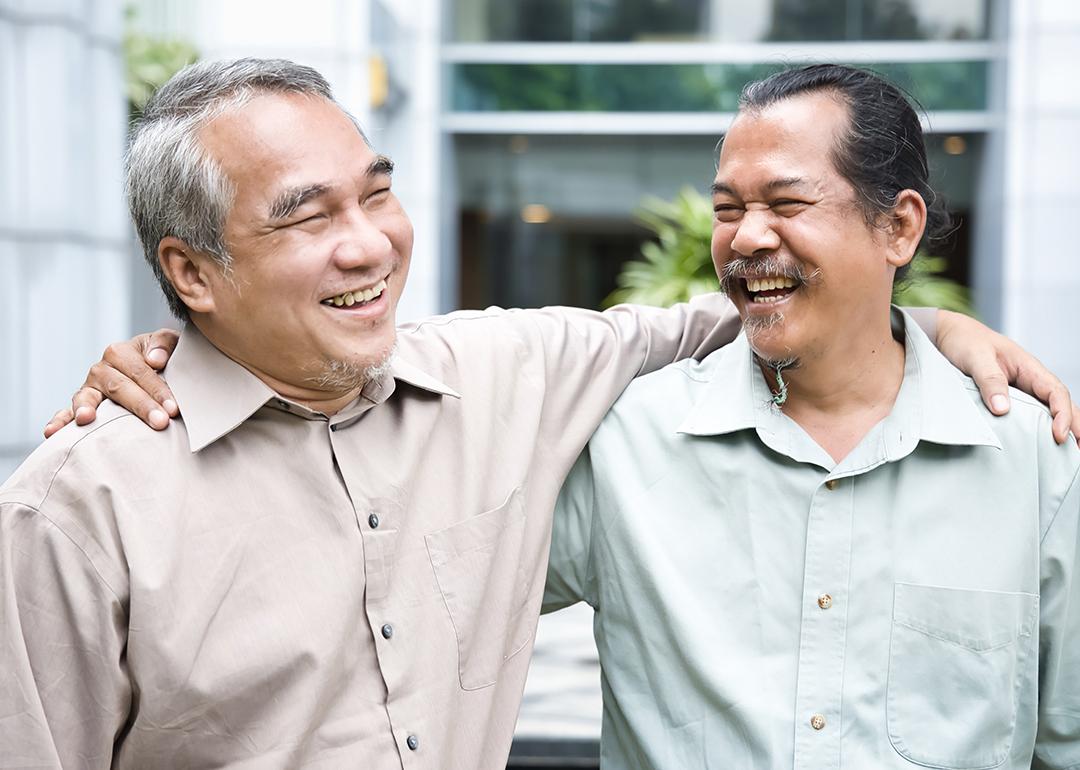 Two older male friends happy to see each other during a reunion.