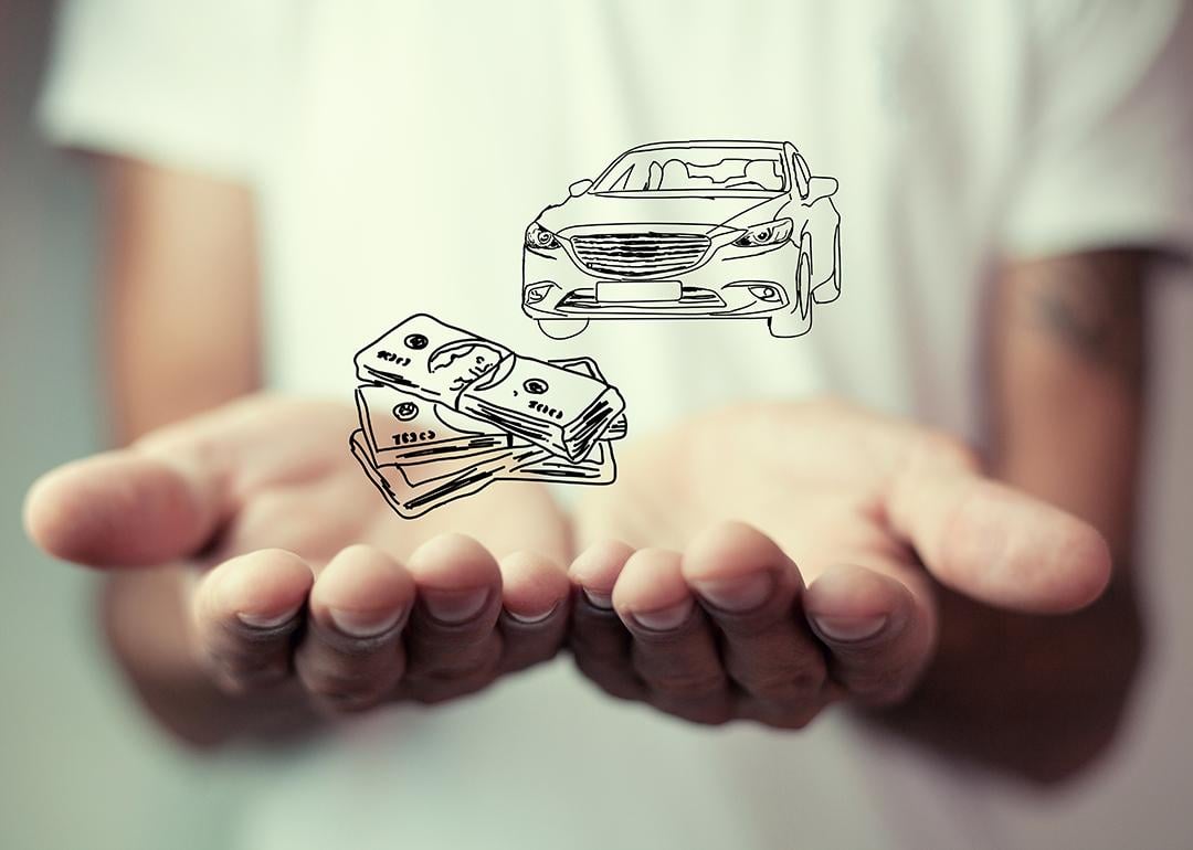 Person holding over an illustration of cars and money as a concept of insurance.