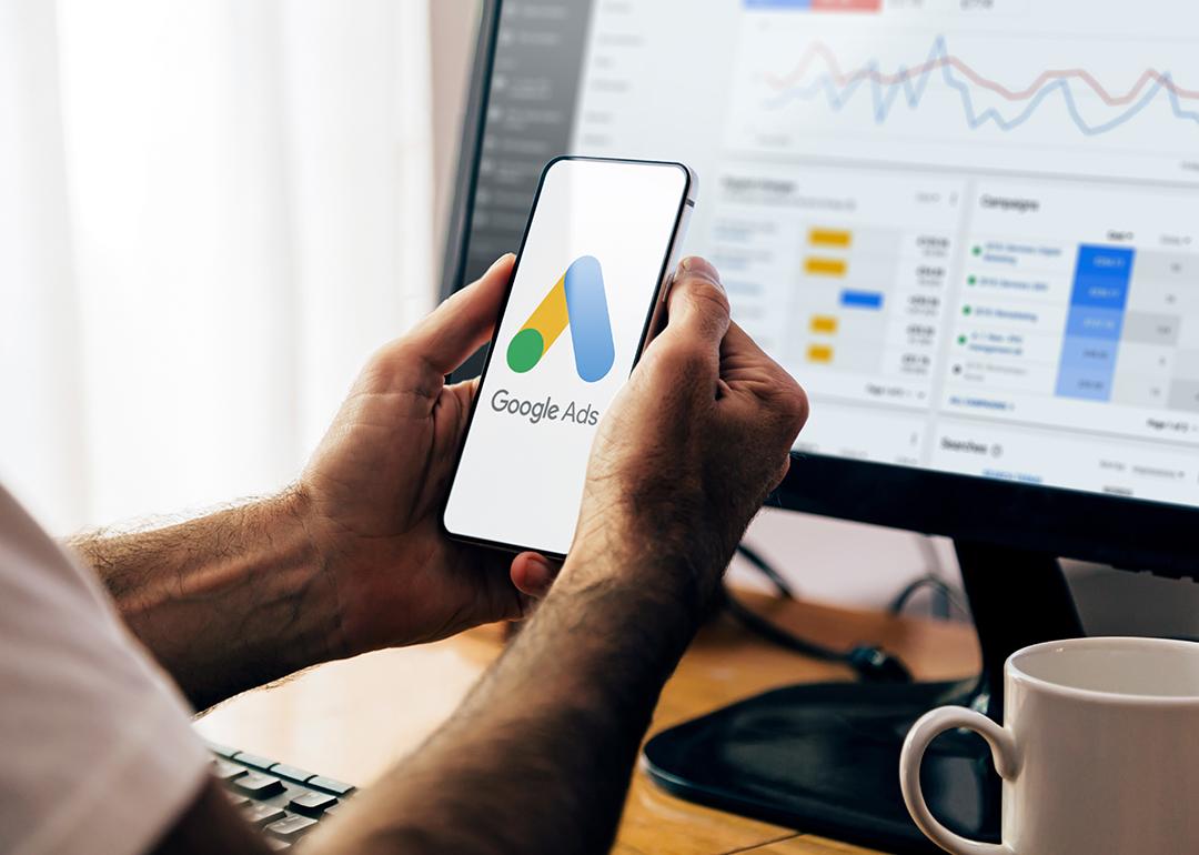 Man using a mobile phone with Google Ads on the screen.