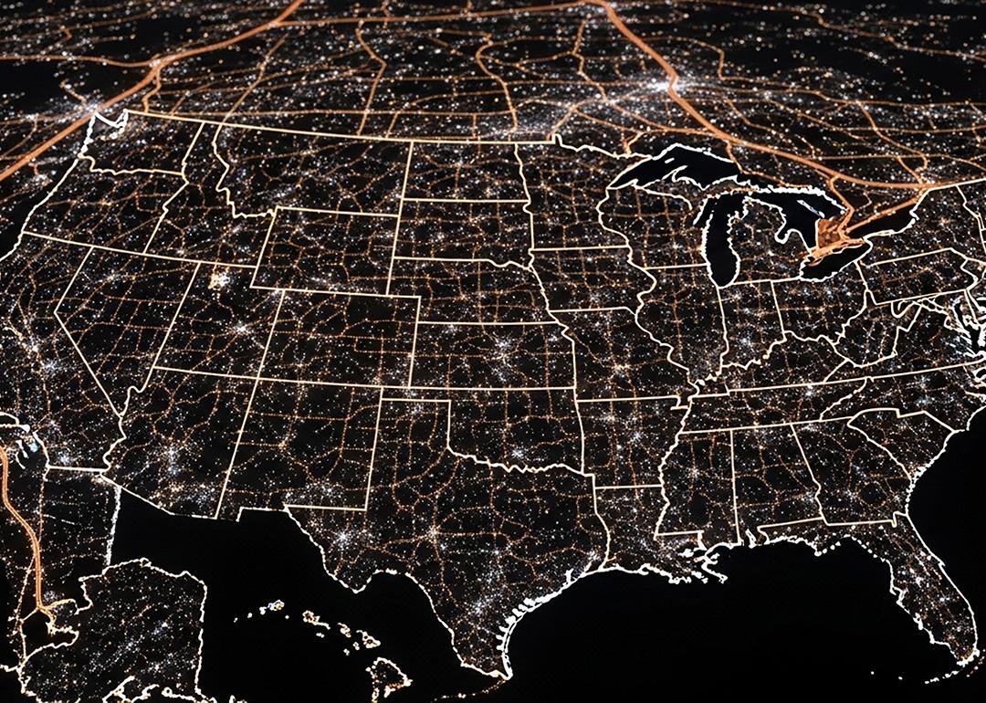 A view of the United States of America at night, highlighted by city lights.